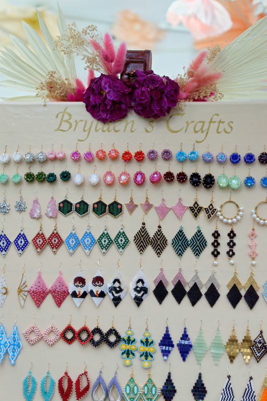 An artisan board from Brynn's Crafts showcasing a variety of handmade beaded earrings
